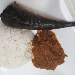 A picture of Boiled rice with carrot sauce and fish.