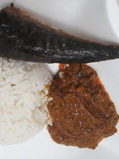 A picture of Boiled rice with carrot sauce and fish.