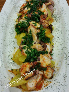 Una foto de Pulpo al ajillo con crujiente de perejil y patata