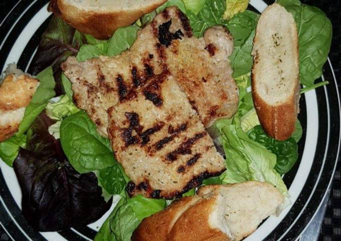 Grilled pork with salad and garlic bread