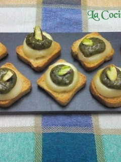 Una foto de Tostas de pesto de pistachos sobre queso rulo