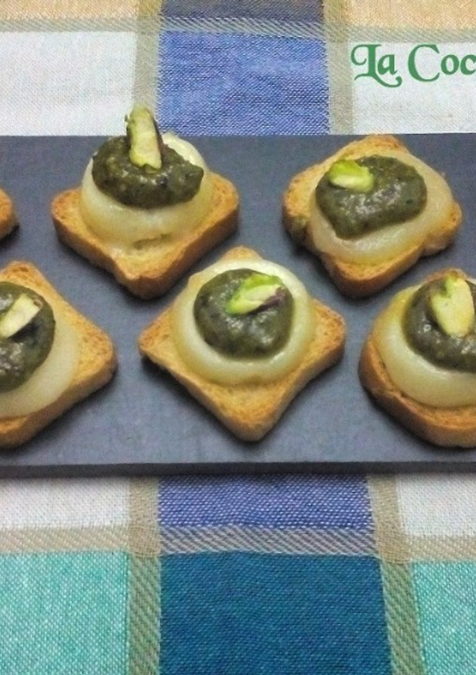 Una foto de Tostas de pesto de pistachos sobre queso rulo 
