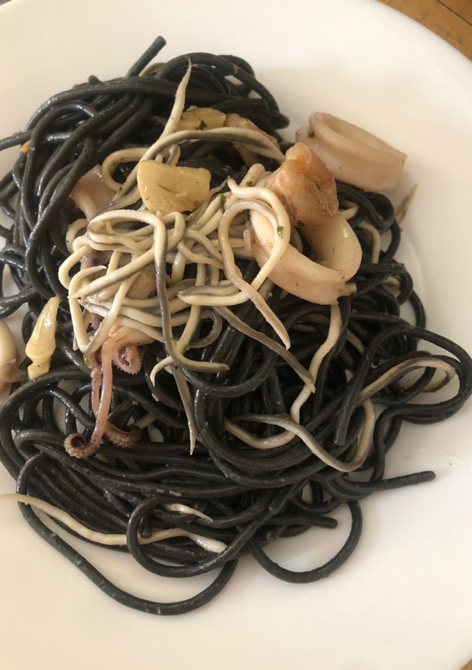 Una foto de Spaghetti al nero di seppia con gulas, gambas y calamares
