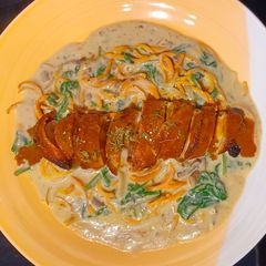 A picture of Creamy mushroom carrot pasta with bacon-wrapped chicken breast.