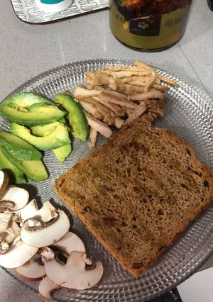 Una foto de Tostada de pan integral con pollo, aguacate y champiñones