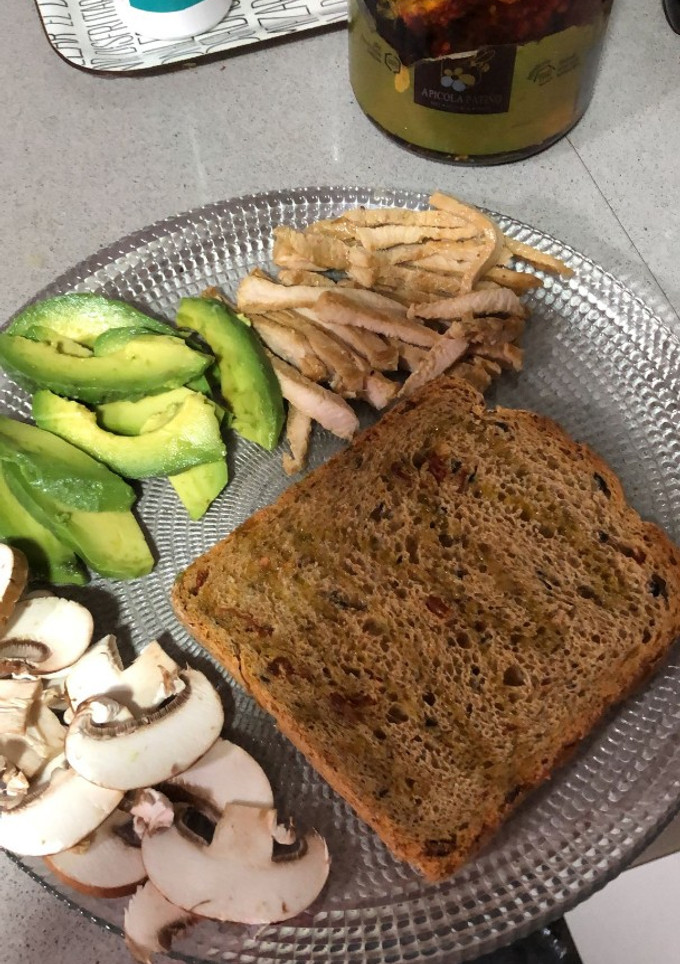 Una foto de Tostada de pan integral con pollo, aguacate y champiñones