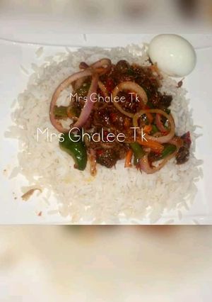 A picture of White rice with onion sauce and egg.