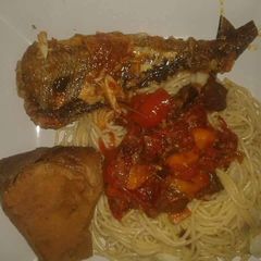 A picture of Spagetti with tomato sauce with grilled fish.
