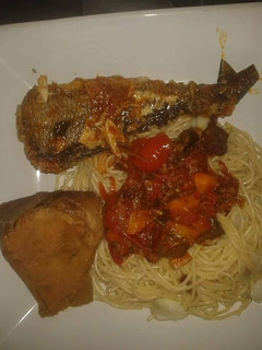 A picture of Spagetti with tomato sauce with grilled fish.