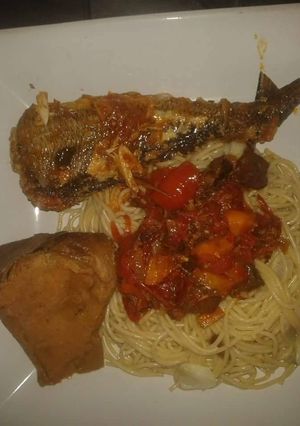 A picture of Spagetti with tomato sauce with grilled fish.