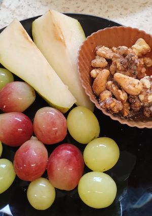A picture of Sliced 🍐 and grapes with walnuts. Healthy Juicy snack.