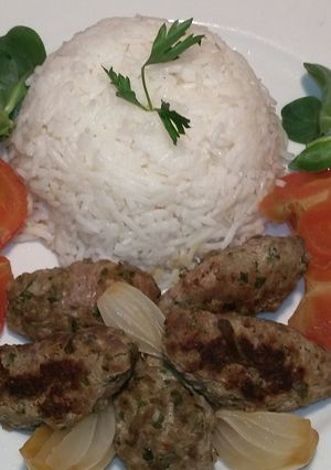 A picture of Grilled Kofta Fingers with Onions and Tomatoes.