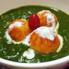 A picture of Kofte in spinach gravy.