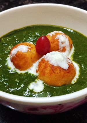 A picture of Kofte in spinach gravy.