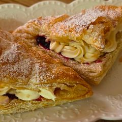 A picture of Puff pastries with mascarpone and blueberry sauce.