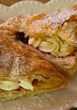 A picture of Puff pastries with mascarpone and blueberry sauce.