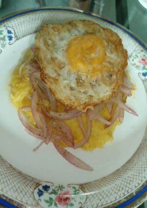 Una foto de Mangú de plátano maduro con huevo y cebolla
