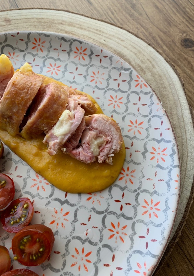 Una foto de Enrollado de pollo relleno de jamón y queso con salsa de verduras