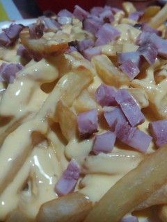 Una foto de Papas fritas con salsa cheddar y panceta