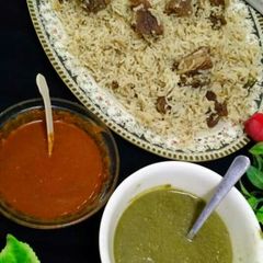 A picture of Yakhni pulao with lal mirch and green chutney.