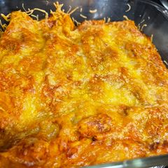A picture of Chicken enchiladas with red sauce.
