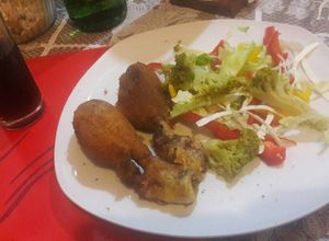 Una foto de Pollo estilo KFC con ensalada multicolor