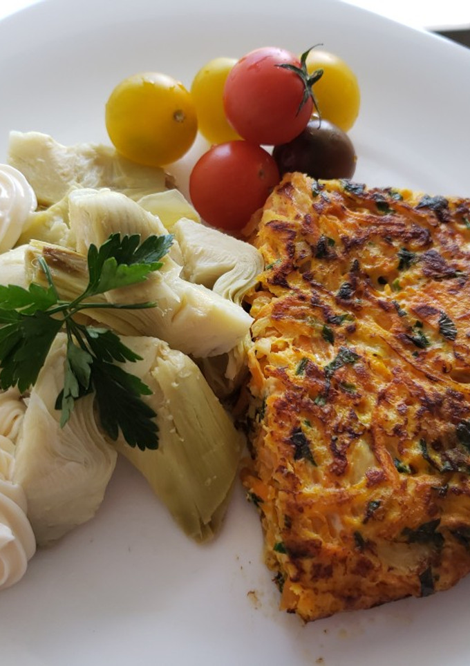 Una foto de Tortilla de zanahoria con fondos de alcachofa y tomates cherry