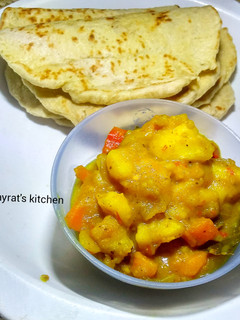A picture of Naan bread and buttered potatoe curry soup.