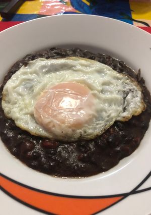 Una foto de Frijoles con chorizo, con huevo estrellado encima