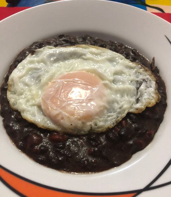 Una foto de Frijoles con chorizo, con huevo estrellado encima