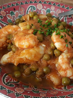 Una foto de Merluza con gambas y guisantes