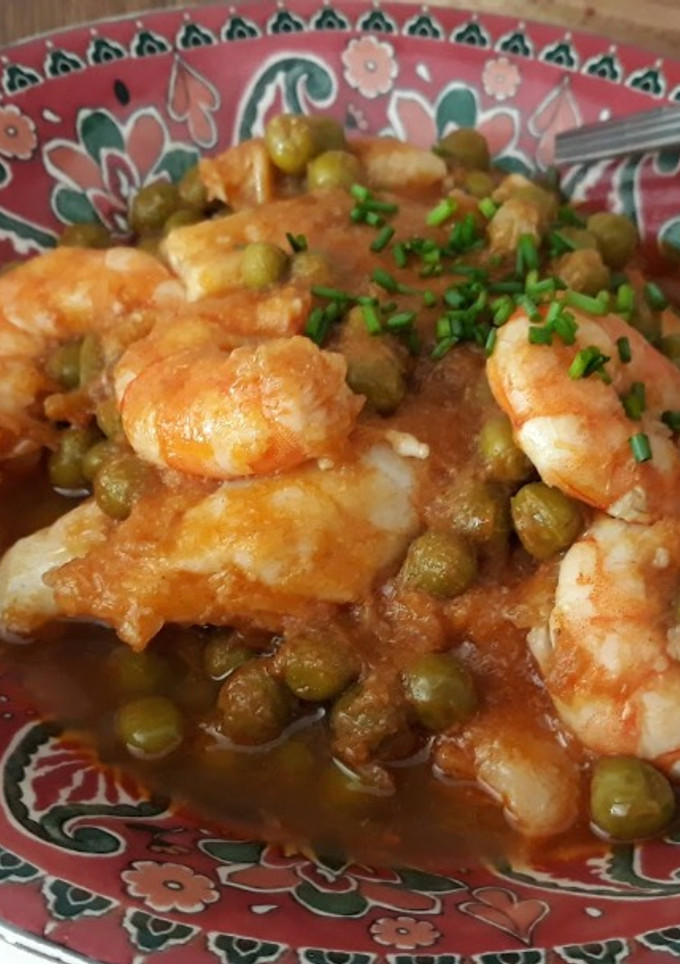 Una foto de Merluza con gambas y guisantes