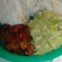 A picture of Wet fried pork with fried cabbages and ugali.
