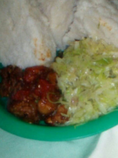 A picture of Wet fried pork with fried cabbages and ugali.