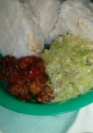 A picture of Wet fried pork with fried cabbages and ugali.