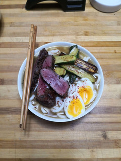 A picture of Udon noodle soup with ostrich steak.
