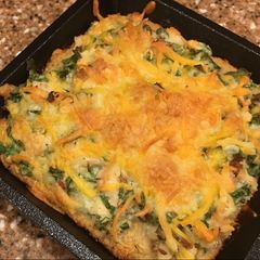 A picture of Pub cheese pizza with chicken, spinach, and bacon.