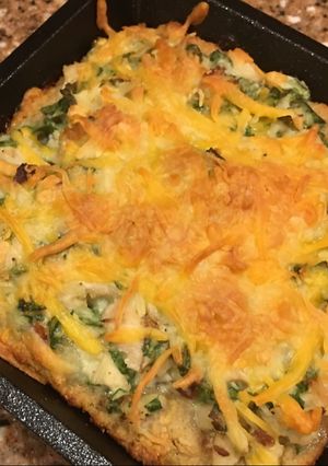 A picture of Pub cheese pizza with chicken, spinach, and bacon.