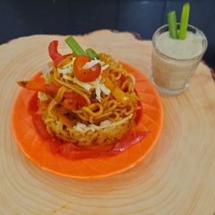 Schezwan noodles in noodles basket with kiwi banana smoothie A picture of Schezwan noodles in noodles basket with kiwi banana smoothie.