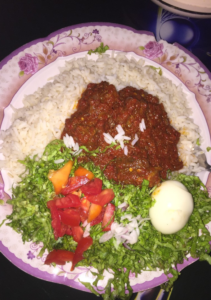 A picture of Rice and stew with salad.