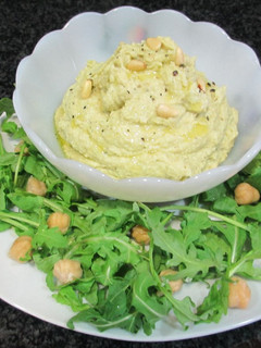 Una foto de Hummus de garbanzos con aguacate, piñones y rúcula - veggie
