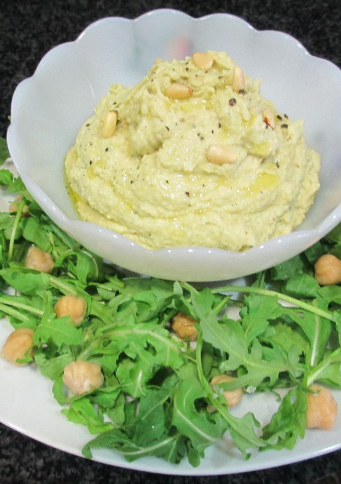 Una foto de Hummus de garbanzos con aguacate, piñones y rúcula - veggie