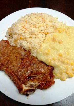 Una foto de TBone a la parrilla, Papasa de Maíz & Arroz de Zanahorias y Apio