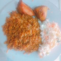 A picture of Jollof rice, coleslaw & chicken.