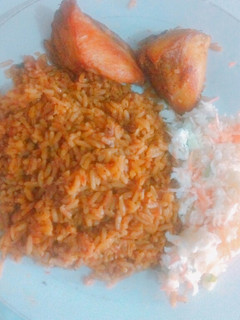 A picture of Jollof rice, coleslaw & chicken.