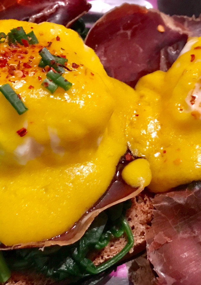 Una foto de Huevos benedict con espinacas y cecina