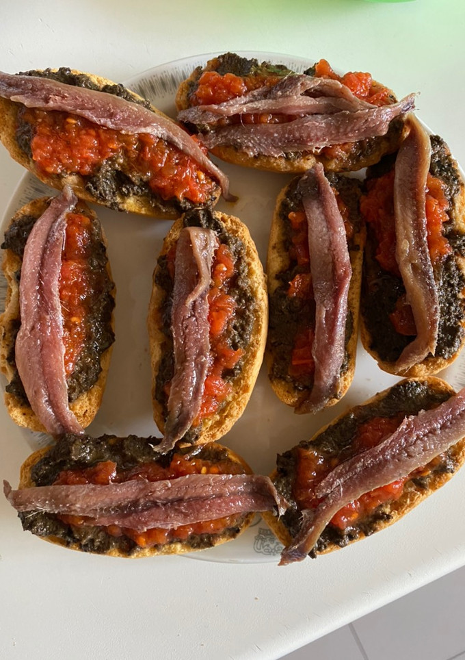Una foto de Anchoas con olivada y tomate