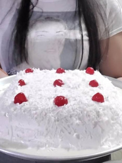 A picture of Tres Leches Cake with Whipped Cream and Shredded Coconut with Cherries.