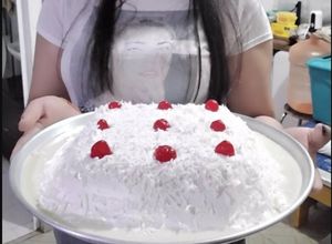 Una foto de Pastel de Tres leches cubierto de Crema y Coco rallado con cerezas