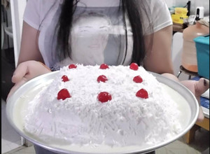 Una foto de Pastel de Tres leches cubierto de Crema batida y Coco rallado con cerezas
